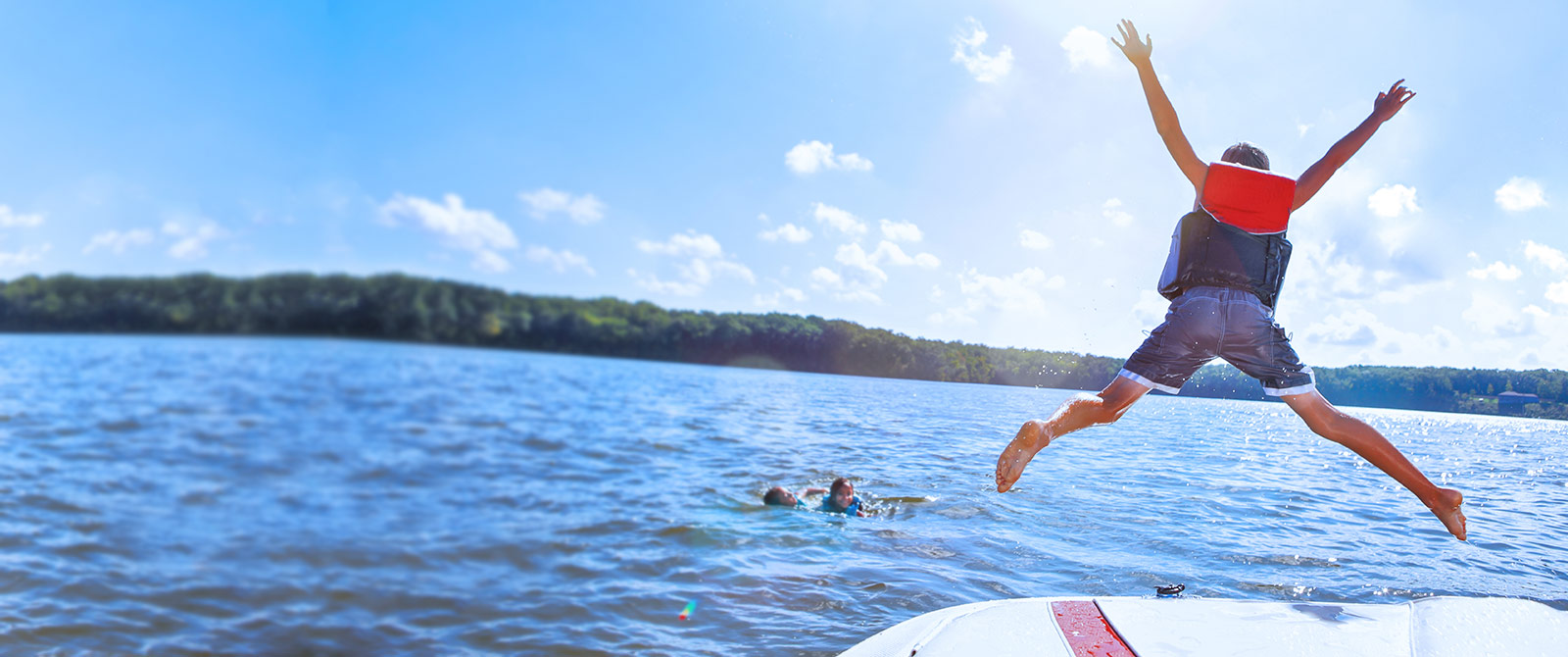 Boy jumping off boat